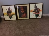 Three framed African motif art prints displayed on the floor, showing overall lot contents.