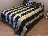 Full bed setup with striped and geometric pattern bedding on a metal frame.