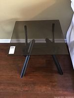 Side angle showing the glass top and metal frame with angled legs.