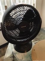 Full view of black Honeywell fan showing front circular grille and fan blades.