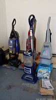Four vacuum cleaners arranged together showing the models and overall condition.