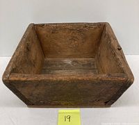 Front and top views of rectangular antique wooden box showing interior and aged wood grain.