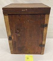 Front view of the antique primitive wooden wall cabinet door with knob, hinges, and overall rustic finish.