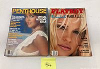 Photo showing two adult magazines, one Penthouse special holiday issue with female model in white dress on cover, and one Playboy issue featuring Pamela on cover.