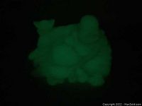 Glow in the dark photo showing the green Buddha sculpture glowing.
