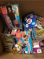 Box open showing packaged 1980s style apparel including mesh top, animal and zebra print pants, inflatable boombox and accessory packets.