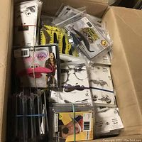 Top view of a cardboard box containing 17 new adhesive costume beards and moustaches in blister packaging with printed face images.