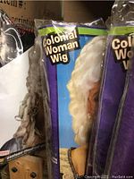 Close up photo of Colonial Woman Wig packaging showing white curled wig