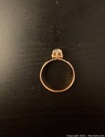 Side profile of ring showing band and setting on black surface