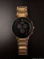 Front view of Citizen watch showing black dial with three subdials and gold-tone bracelet with wear.