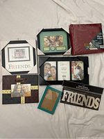Photo showing multiple new photo frames and a red photo album, plus 'Friends' mirror sticker sheet.