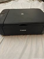 Front view of the Canon Pixma device showing brand label and printer output area.
