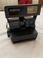 Front view of Polaroid OneStep Close-Up camera showing flash, lens, and viewfinder with some scratches on body.