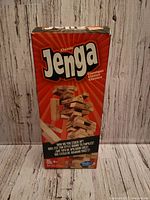 Front of the Jenga box showing the classic logo and images of the game in play.