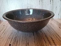 Side view of large Pyrex mixing bowl with grey, black, and white speckled pattern showing curved profile and wide rim