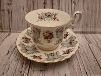 Teacup and saucer set front angle, showing floral pattern and gold trim