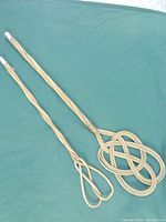 Full view of both bamboo rug beaters showing length and woven loop designs.