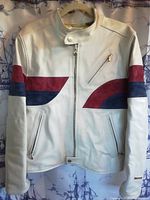 Front view of cream leather jacket with red and navy suede panels and zipped pockets
