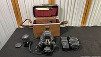 Full lot setup showing Canon A-1 camera with Canon 50mm lens attached, Tokina 35-105mm zoom lens, Vivitar 3500 flash unit, and camera manual inside hard-sided case.