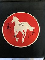 Front side of the promo featuring the white horse silhouette on red background with multiple autographs in black ink.