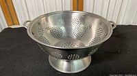 Full view of the aluminum colander showing Mickey Mouse head perforations and pedestal base