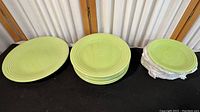 Photo showing all plates grouped by size on a black surface under indoor lighting