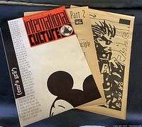 Three magazine booklets displayed together showing covers and interior pages with graphic prints and text.
