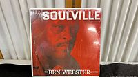 Front cover of the sealed vinyl record showing the album title 'Soulville' and artist 'The Ben Webster Quintet' with a red background and close-up of Ben Webster's face.