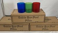 Three stacked boxes labeled 'Table-Bar-Pool & Patio' with one tumbler of each color (blue, green, red) placed on top.