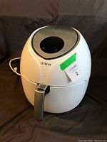 Front view of Ultrean air fryer showing white plastic body, grey handle, digital control panel on top area.