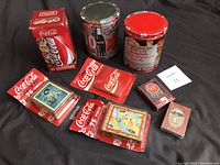 Full collection shown including puzzles, playing cards, and coasters all Coca-Cola themed.