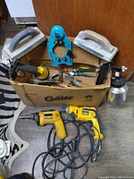 Full lot overview showing drills, trowels, spray gun, and hand tools in box