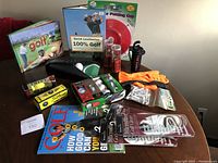 Full view of golf lot showing multiple golf accessories, balls, gloves, and books arranged on table