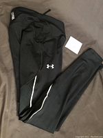 Black women's tights folded showing Under Armour logo and reflective stripes.