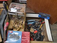 Box of assorted woodworking and workshop tools including sanding drum kit, drill bits, jigsaw, clamps, glue tools and tool pouch.