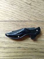 Side view of the miniature shoe-shaped knife showing detail and decorative rivets.