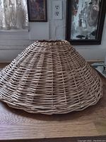 Side view of the large wicker lampshade showing its conical shape and woven wicker material.