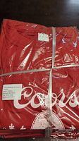 Packaged bundle of 10 red Coors Banquet women's T-shirts, size large, showing front print and packaging labels.