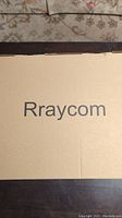 Closed cardboard box with 'Rraycom' brand printed on cover for security camera system