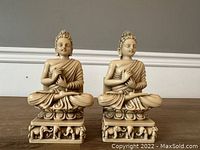 Pair of carved beige Buddha statues positioned side by side on base, both facing forward, shown as bookends.