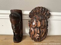 Photo showing two carved wooden African figures side by side, highlighting their size and design details.