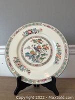 Full view of the Wedgwood decorative plate standing upright on a black stand showing the bird and floral motifs on the face.