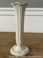 Front view of antique Royal Worcester vase showing flared scalloped rim and vertical ribbed plant design.