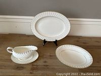 Full view of the set showing platter, bowl, gravy boat, and underplate on wood surface with light background.