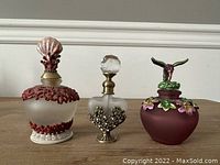 Three Czech glass perfume bottles with ornate stoppers, showing entire lot.