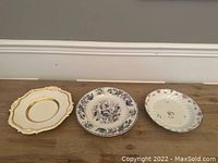 Three antique English porcelain plates laid out side by side showing various decorative styles and sizes.
