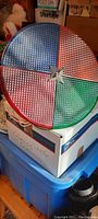 Front view of the spinner sign showing the four colored textured sections (red, green, blue, and white) and central star fastening.