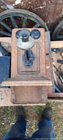Top view of the wooden wall phone cabinet showing the metal mouthpiece and black bell mounted on the wood.