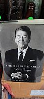 Hardcover book 'The Reagan Diaries' dust jacket front showing a seated Ronald Reagan portrait and title with his signature.