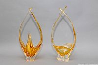 Front view of two amber freeform blown glass bowls with pointed upward extensions